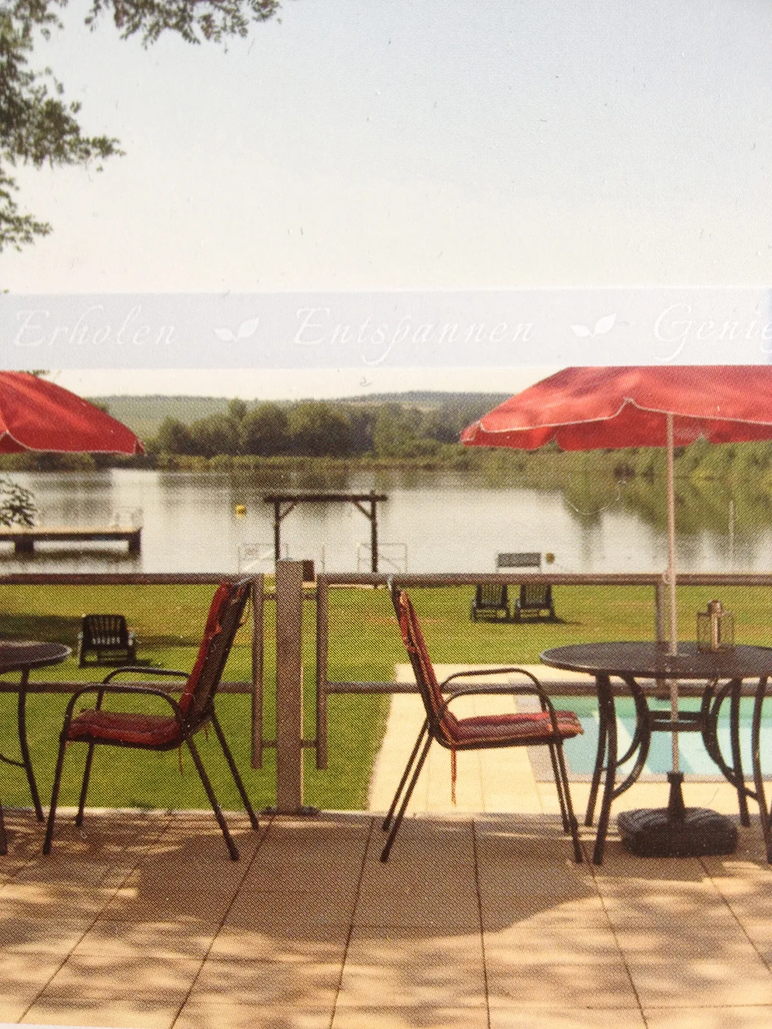 Terrasse mit Sonnenschirmen und Blick über den Teich