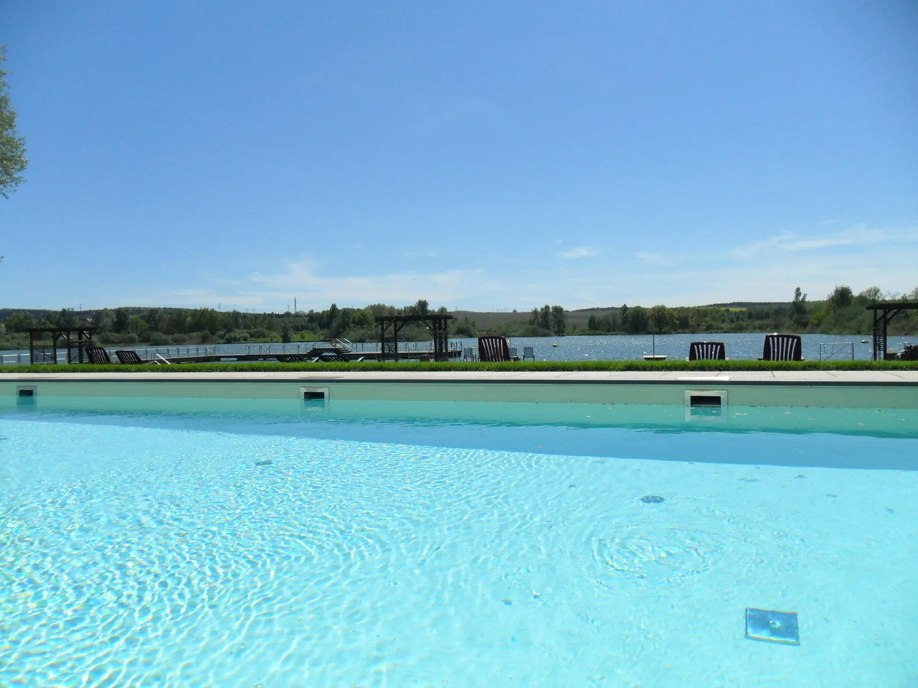 Außenpool mit klarem Wasser und Blick auf den Teich