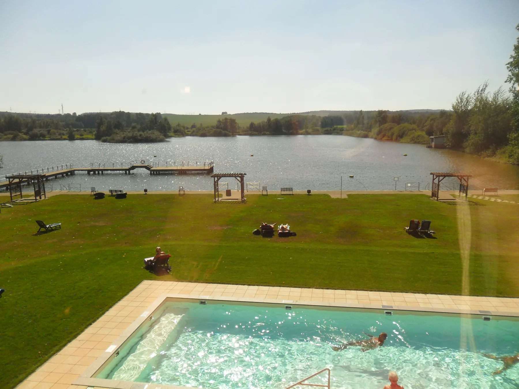 Blick von der Terrasse über Pool, Wiese und Teich