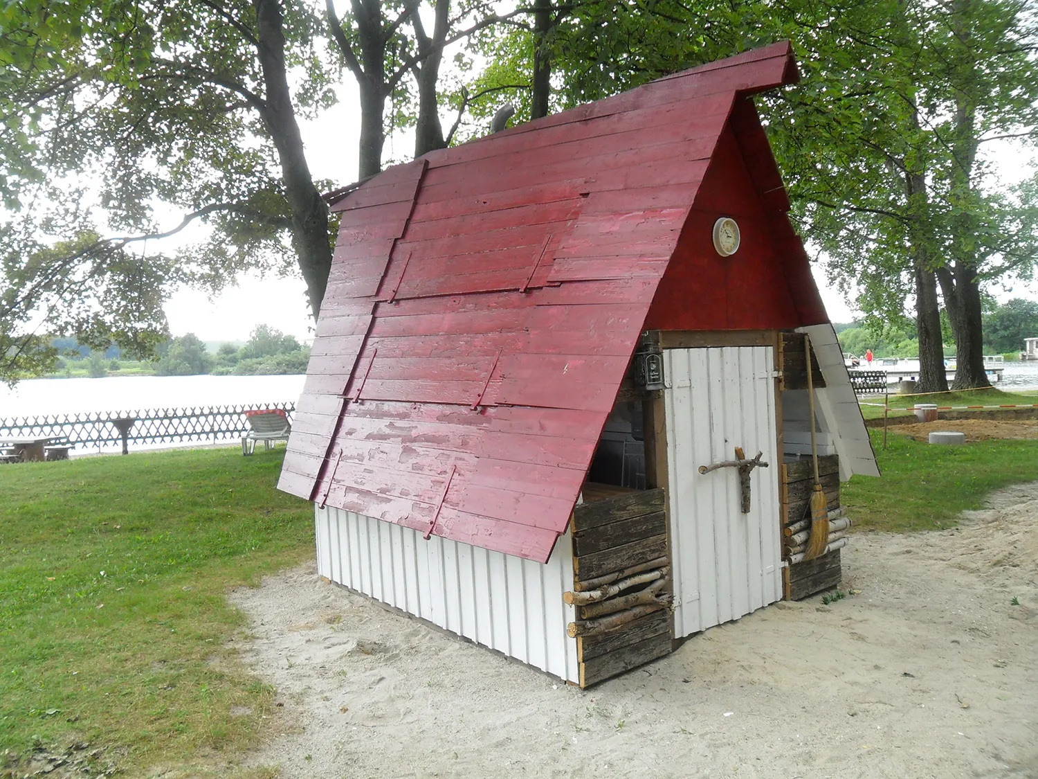 Kleines Holzhaus mit rotem Dach auf dem Gelände