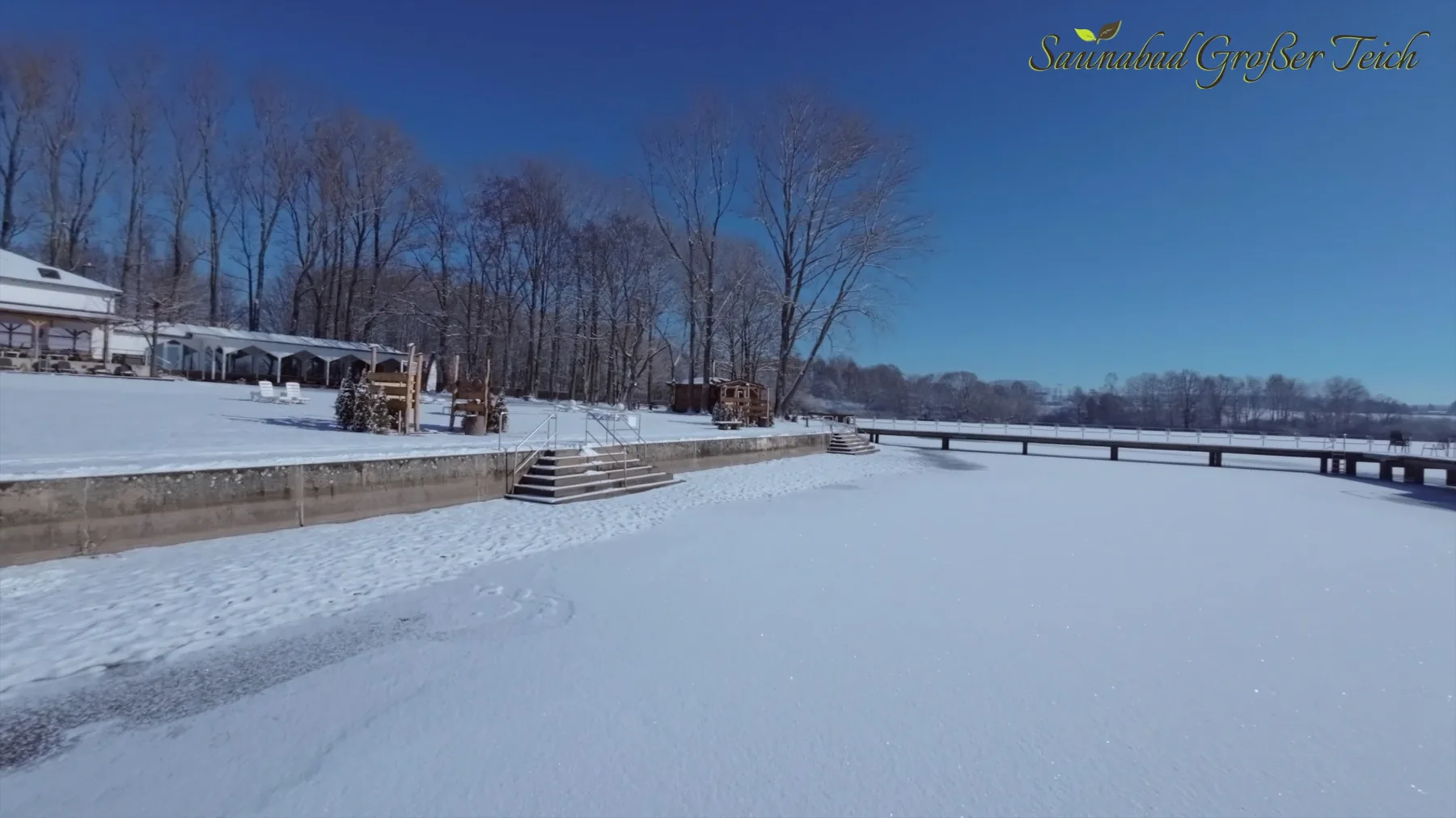 Verschneite Liegewiese und Steg am Großen Teich im Winter