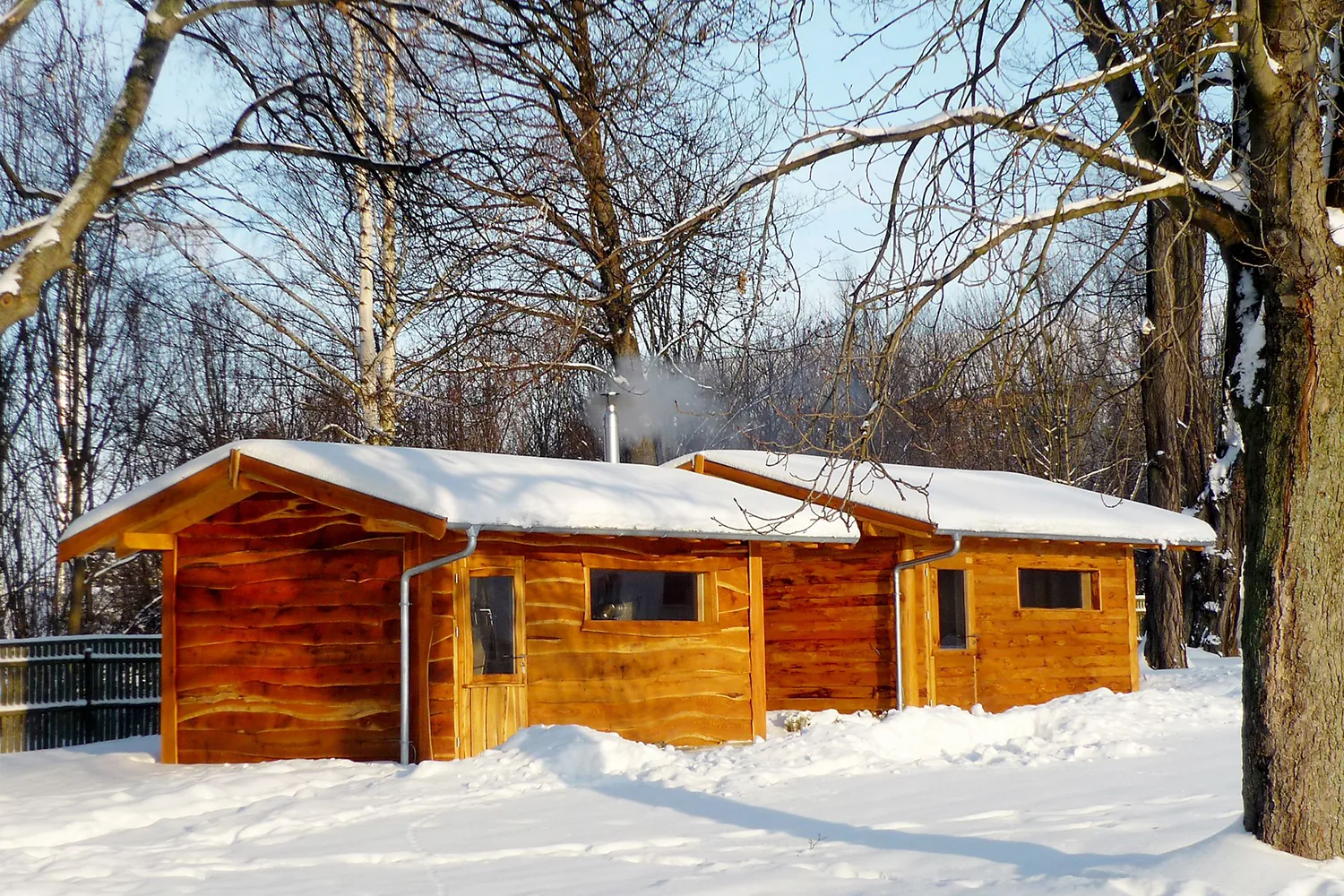 Blockhaussauna aus Holz mit Schnee auf dem Dach